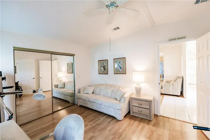 Living room featuring ceiling fan, vaulted ceiling, and light hardwood / wood-style floors