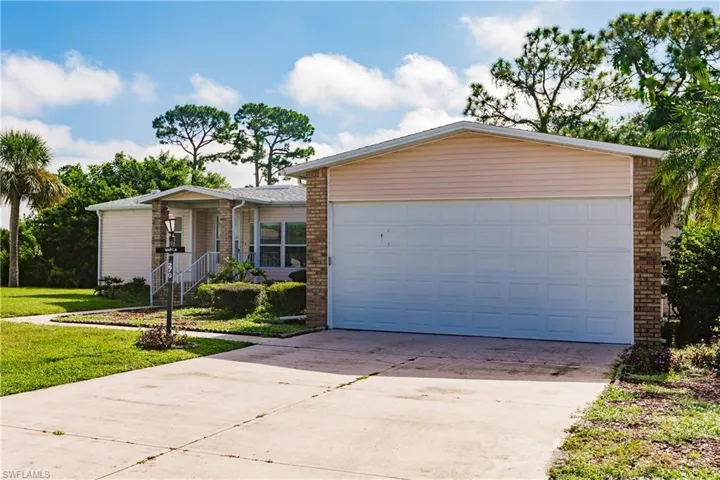 Ranch-style home featuring a garage and a front lawn