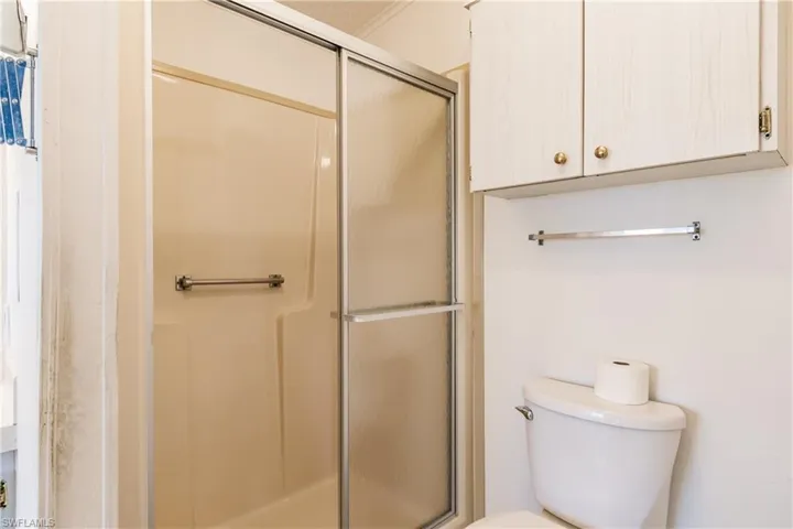 Bathroom featuring ornamental molding, toilet, and walk in shower
