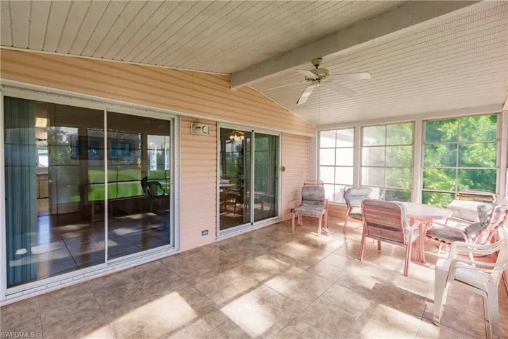 Unfurnished sunroom featuring ceiling fan and vaulted ceiling with beams