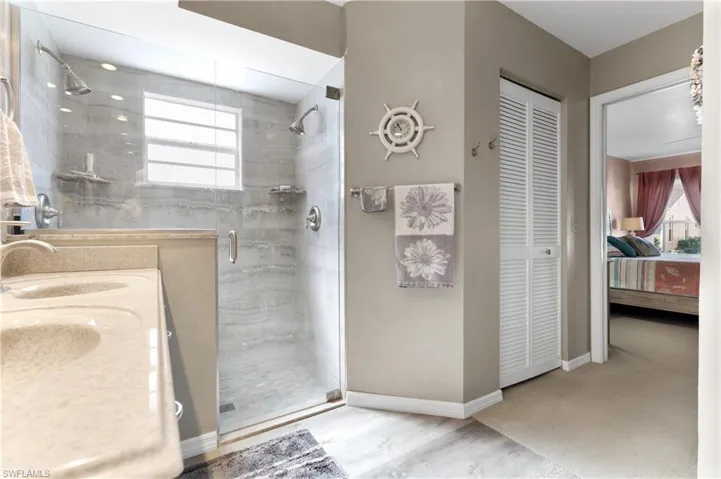 Ensuite bathroom with a closet, a stall shower, and double vanity