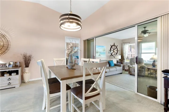 Dining space with light carpet, high vaulted ceiling, and a chandelier