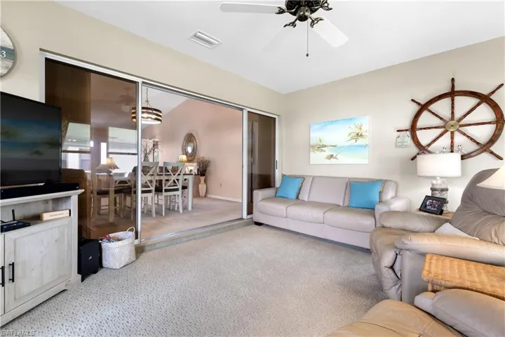 Living room featuring carpet flooring and ceiling fan
