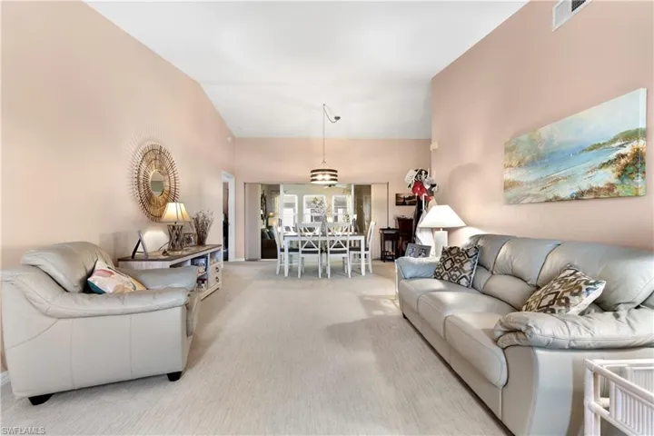 Living room with carpet floors and high vaulted ceiling