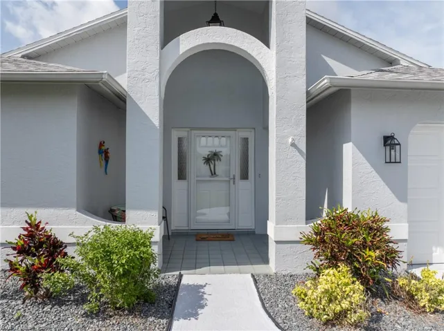 View of exterior entry featuring stucco siding and an attached garage