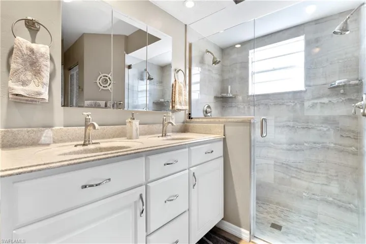 Full bathroom with a shower stall and double vanity