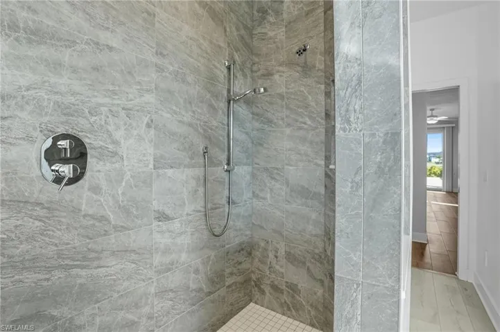 Full bath with a tile shower and wood finished floors