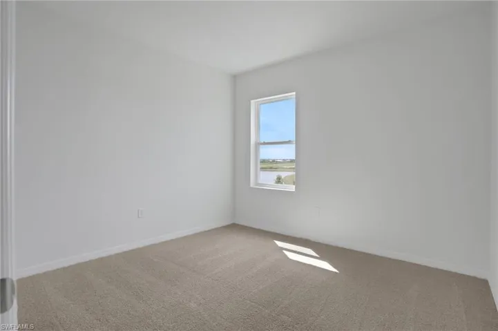 Unfurnished room featuring light colored carpet and baseboards
