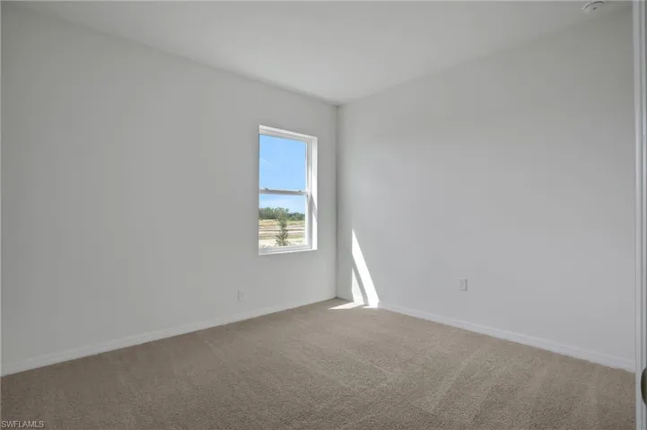 Empty room with carpet floors and baseboards