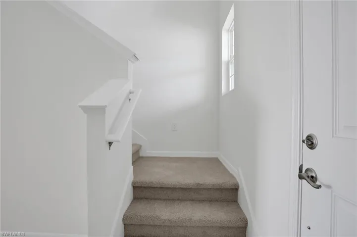 Stairway featuring carpet floors and baseboards