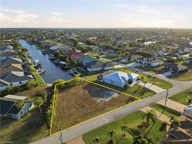 Aerial view of residential area featuring property parcel outlined and a nearby body of water