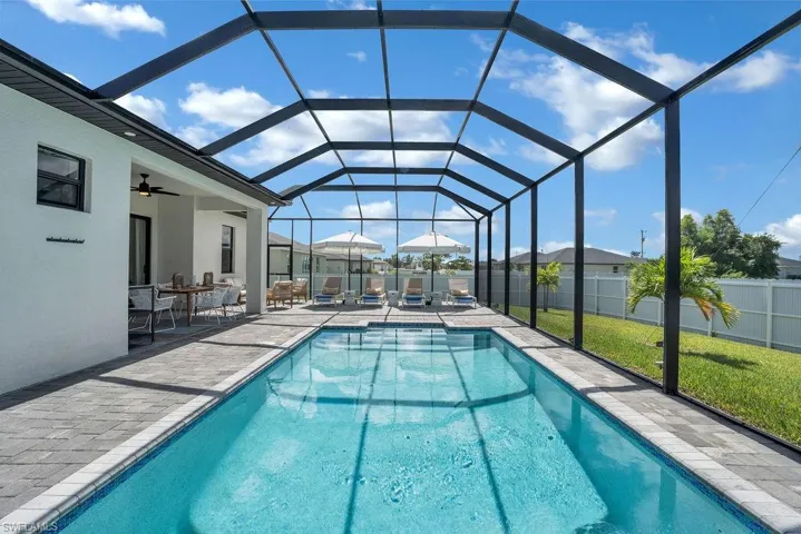 View of swimming pool featuring a lanai, a sunroom, and a patio area