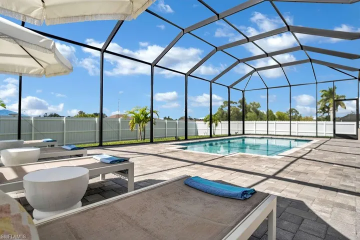 View of pool featuring a lanai, a fenced backyard, a sunroom, and a patio