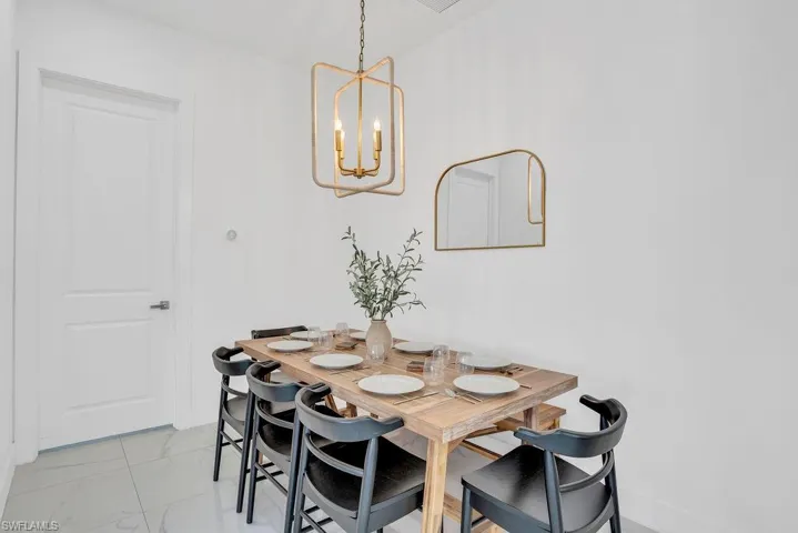 Dining room with light marble finish flooring and a chandelier