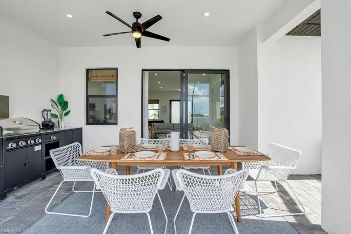 View of patio featuring outdoor dining area, a ceiling fan, and grilling area