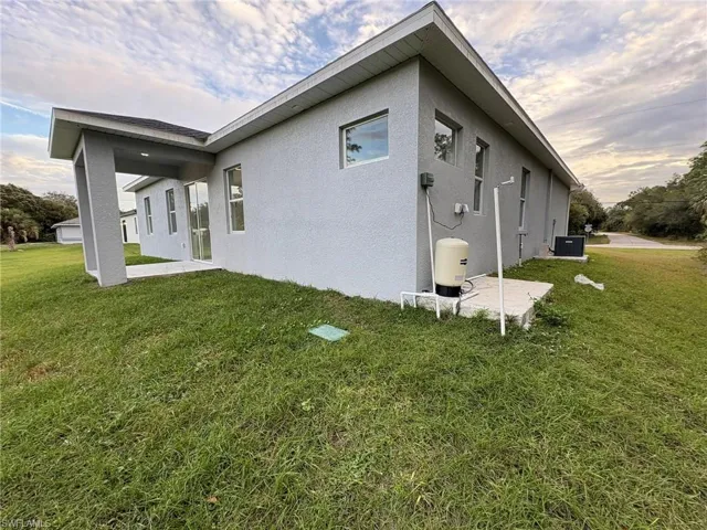 Rear view of property with a patio area, a yard, and stucco siding