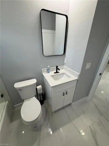 Bathroom featuring light marble finish floors, vanity, and bathtub / shower combination