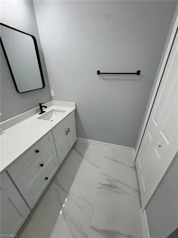 Bathroom featuring light marble finish floors and vanity