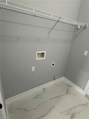 Laundry area featuring marble look tiles, hookup for a washing machine, and electric dryer hookup