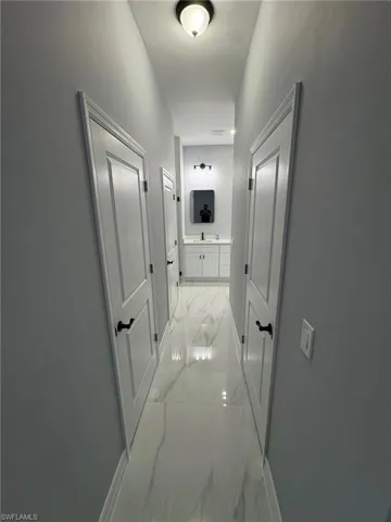 Hall featuring light marble finish floors and baseboards