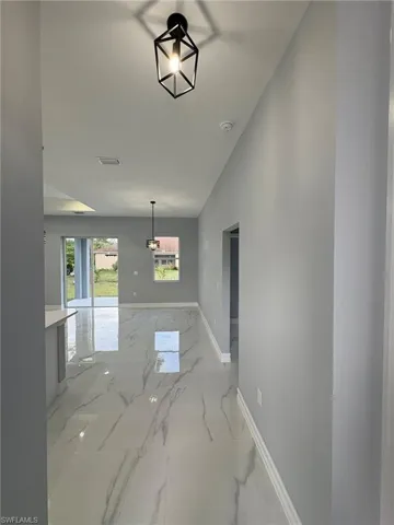 Dining space with light marble finish floors and baseboards