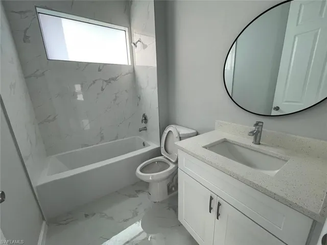 Full guest bathroom featuring vanity, toilet, tiled shower / bath, and tile patterned flooring