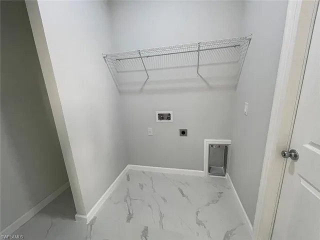 Washroom with hookup for an electric dryer, tile patterned flooring, and hookup for a washing machine