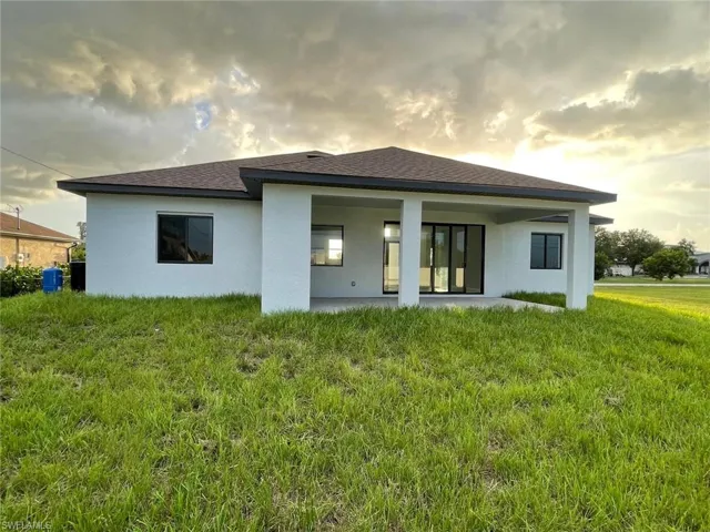 Back house at dusk with a lawn
