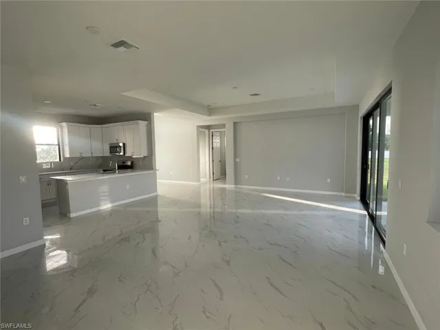 Unfurnished living room featuring sink and light tile patterned floors