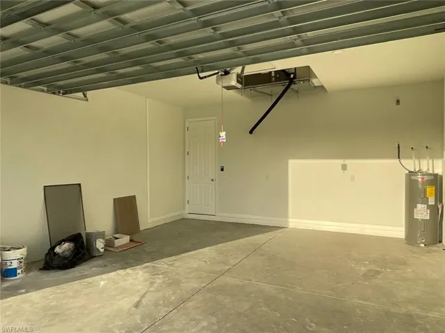 Garage featuring a garage door opener and water heater