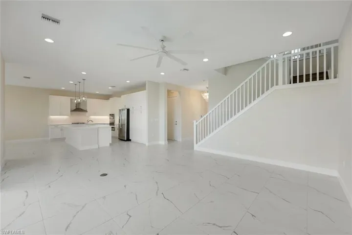 Unfurnished living room with sink and ceiling fan