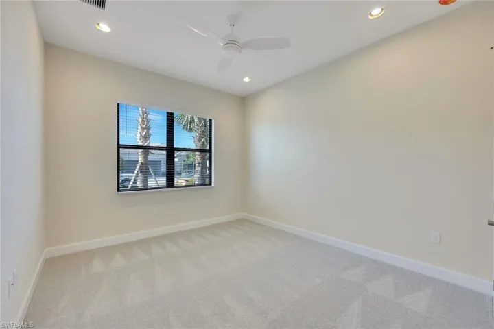 Carpeted empty room with ceiling fan