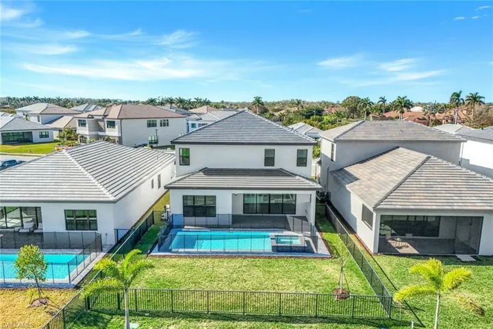 Rear view of property with a fenced in pool and a yard