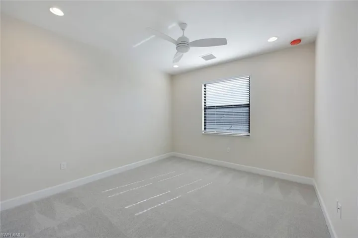 Unfurnished room with ceiling fan and light colored carpet