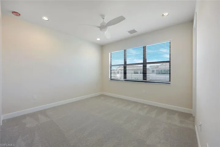 Carpeted spare room with ceiling fan