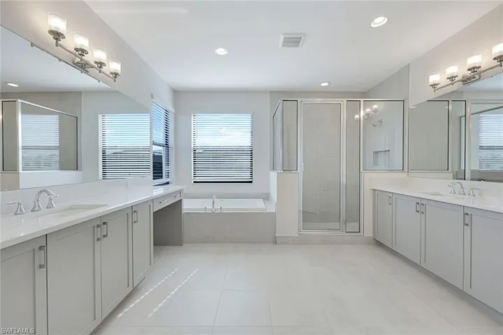 Bathroom with vanity, tile patterned floors, and plus walk in shower