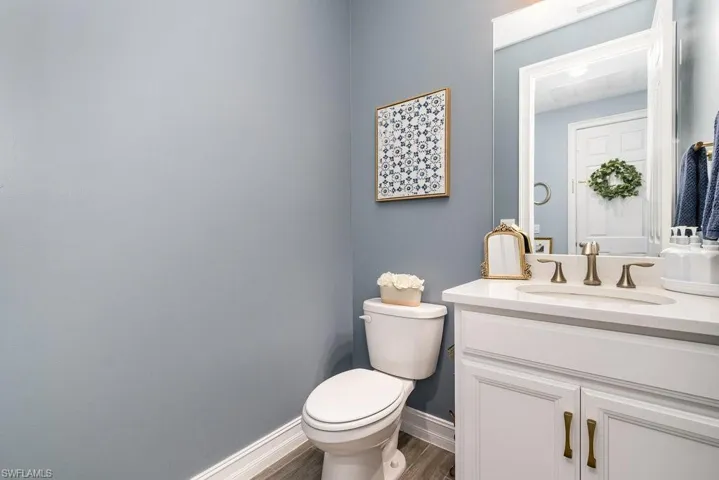 Bathroom with hardwood / wood-style floors, vanity, and toilet