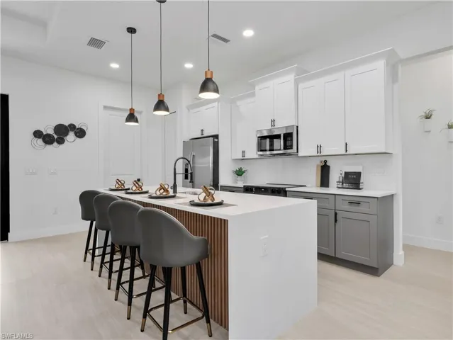 Modern kitchen featuring light wood-finish flooring and a central island with a slatted wood-finish accent panel