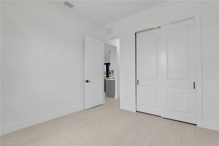 Room featuring light wood-finish flooring, white walls, and white baseboards
