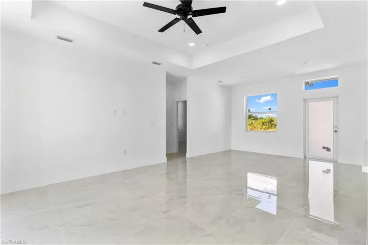 Unfurnished room featuring a tray ceiling, a ceiling fan, and recessed lighting