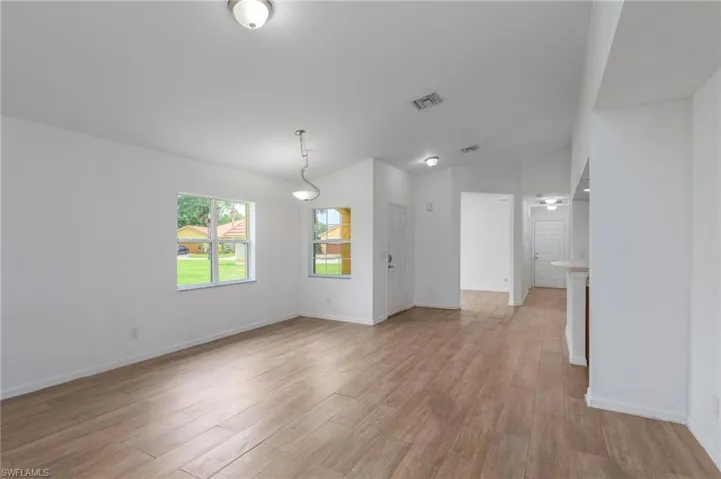 Unfurnished living room featuring vaulted ceiling and light wood-style flooring