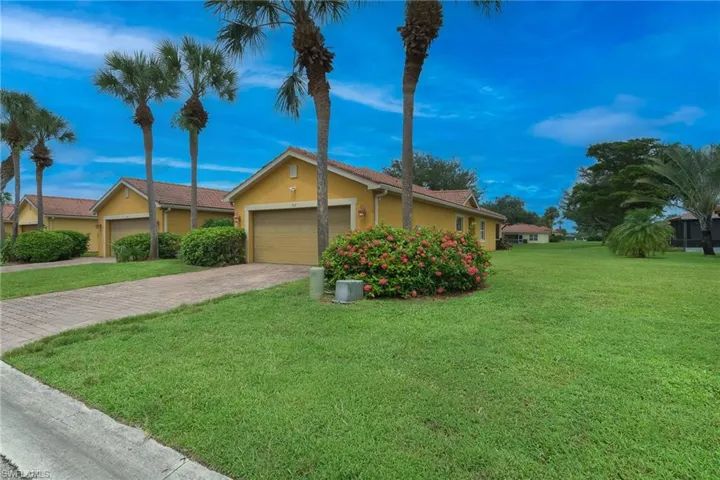 Ranch-style house with stucco siding, a garage, a front yard, and decorative driveway