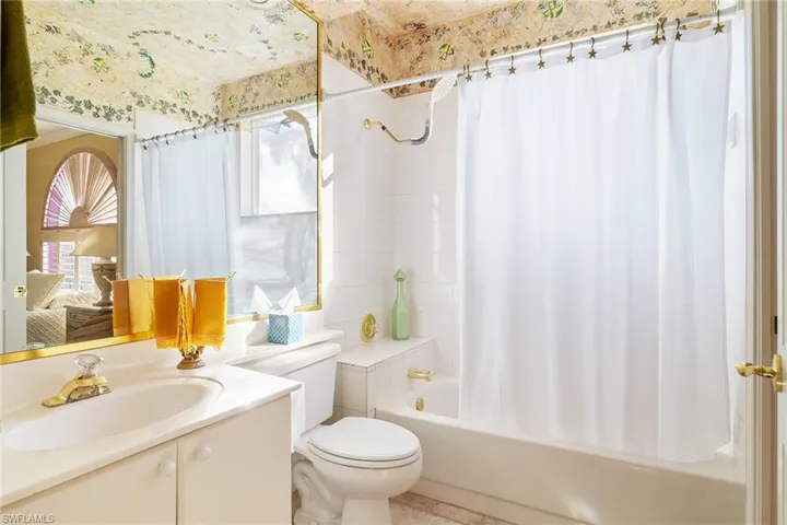 Full bathroom featuring vanity, shower / bath combination with curtain, and toilet
