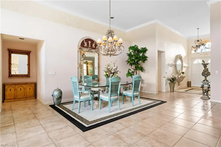 Dining area featuring a notable chandelier, light tile patterned floors, and crown molding