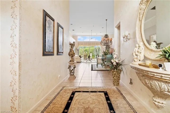 Hall with tile patterned flooring and a chandelier