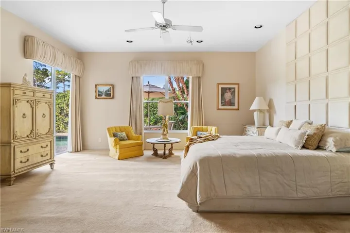 Carpeted primary bedroom featuring ceiling fan, access to outside, and multiple windows