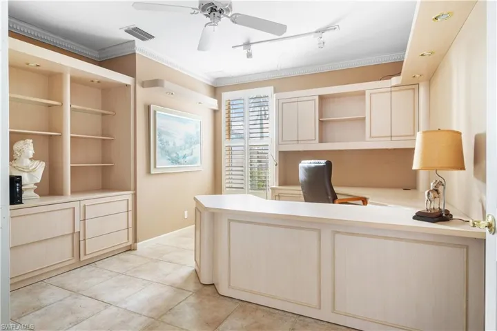 Office space with light tile patterned floors, track lighting, ceiling fan, and ornamental molding