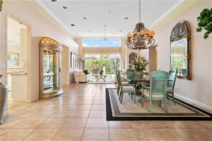 Tiled dining space with crown molding and a chandelier