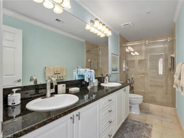 Primary Bathroom with Dual Sinks, Updated Faucets, & Floor to Ceiling Tiled Shower with Updated Glass Shower Enclosure