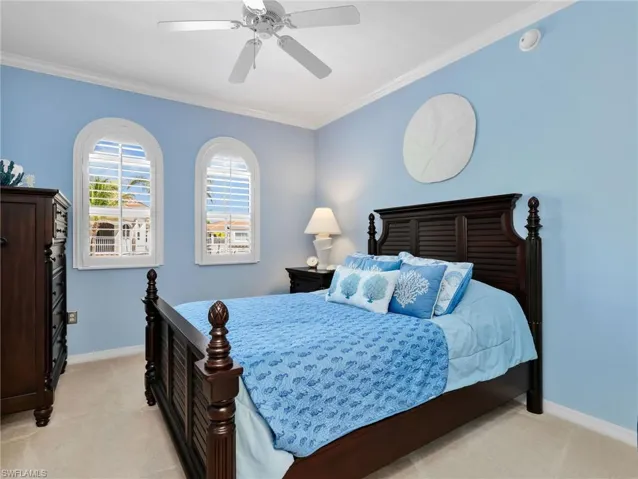 Second Bedroom with Crown Molding, Ceiling Fan, & Arched Windows with Plantation Shutters
